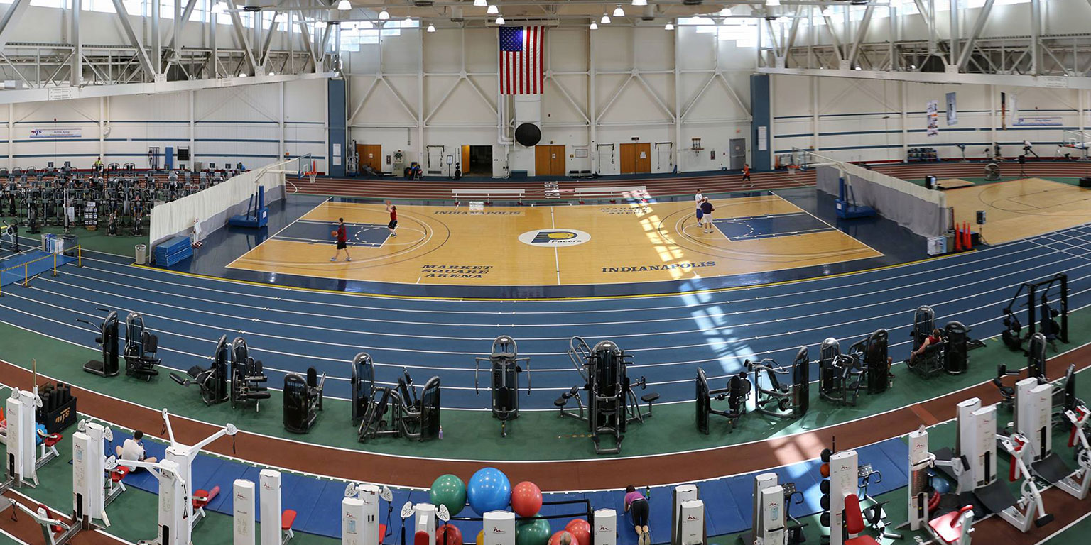 An over head view of the NIFS indoor facility including the track area and various workout equipment. Also includes the basketball court centered in the photo.